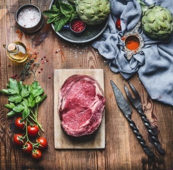 Raw fresh meat Steaks with ingredients for grilling or cooking on rustic wooden background, top view
