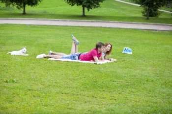 Young happy couple lying in the park on a summer day
