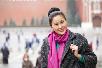 Asian beautiful woman in stylish gray coat on a background of spring street