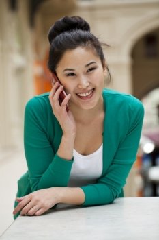 Beautiful asian talking on the mobile phone, indoor