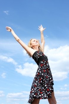 Young woman in summer dress on a background of the blue sky 