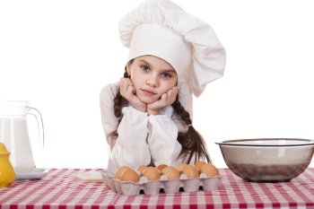 Little girl in a white apron near the box with eggs, isolated on white background