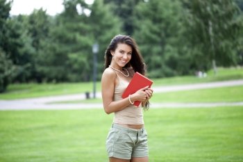 Young beautiful brunette woman and holds book