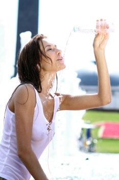 Sexy young woman drinking water from a bottle