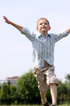 little boy runs in a summer park