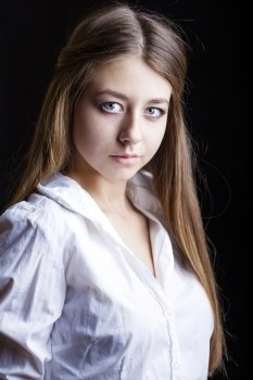 Portrait of beautiful young woman in white shirt, isolated on black background