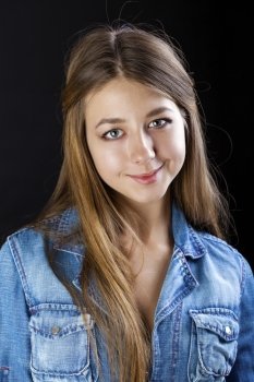 Portrait young girl in a blue jeans jacket, isolated on black background