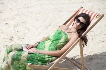 Young beautiful woman relaxing lying on a sun lounger