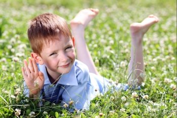 5 years old child lying on the grass. 