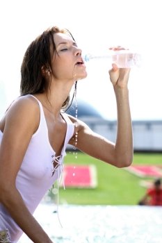 Sexy young woman drinking water from a bottle