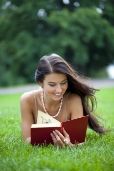 Young beautiful girl reading a book outdoor 