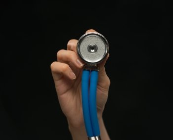 Close-up of female doctor holding stethoscope , focus on stethoscope
