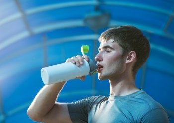 Athletic young man drinking water 