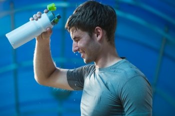 Athlete is refreshing himself with water