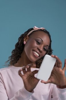 Cute african woman holding smartphone and typing message