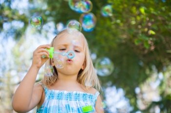 little girl with soap bubbles having fun outdoors