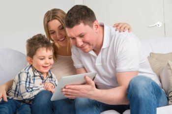 Happy family at home using electronic tablet to play together