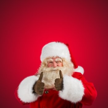 Authentic Santa Claus with real beard and great smiling giving thumb up, isolated on red background with copyspace