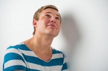 Portrait of a happy young man looking upwards in thought