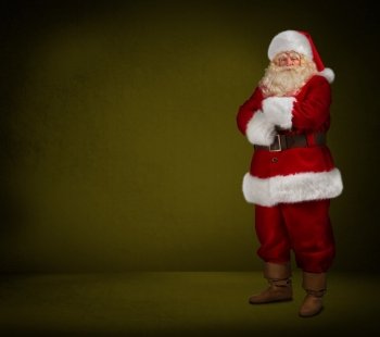 Photo of happy Santa Claus looking at camera on yellow background. Full length portrait