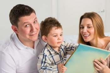 Parents Sitting With Child Reading Story Indoors