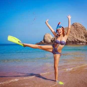 Happy funny girl wearing diving equipment, raised up hands, tropical resort, active lifestyle, summertime hobby, vacation and tourism concept
