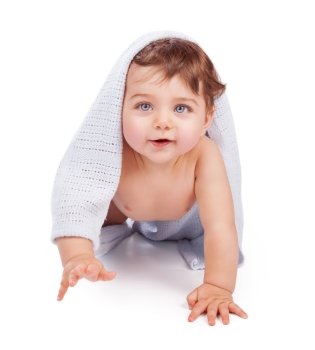 Cute little baby boy wrapped in blue towel after shower crawling in the studio over white background, happy healthy childhood