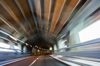 Motion blur driving a car at speed through a road tunnel