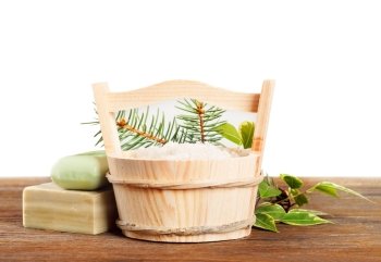 Aromatic bath salt in wooden bucket and handmade soap. Herbal soap and salt on a wooden table.