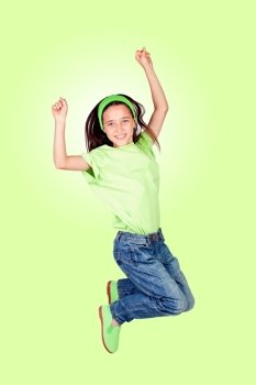 Happy little girl jumping isolated on a green background
