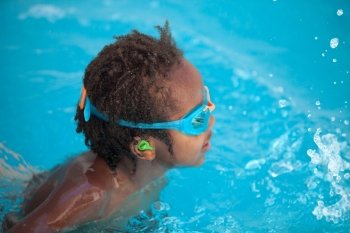 Small African American child with goggles in the pool