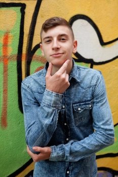Pensive and funny teenager on a wall with graffiti background