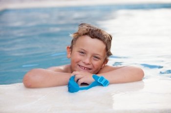 Funny blond boy with swimming goggles in the pool