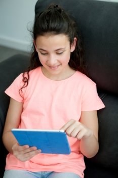 Little girl in the sofa at home with a tablet