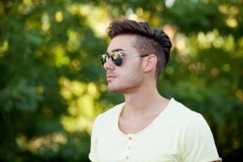 Attractive guy in the park with sunglasses and yellow t-shirt
