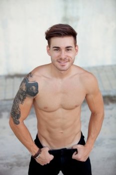 Handsome fit athletic shirtless young man with a tattoo