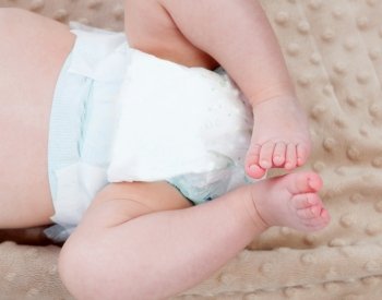 Legs of a baby with diaper on a blanket