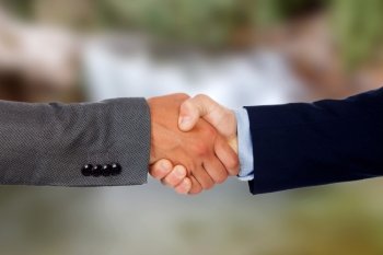 Handshake between businessmen with a unfocused background