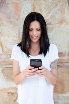 Cool young woman with mobile sending a text message