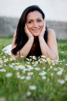 Brunette woman looking at camera on a flowered meadow