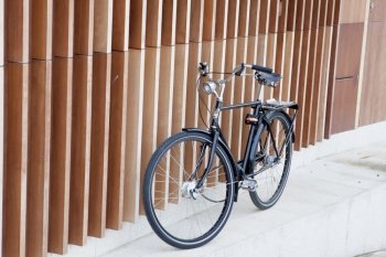 Black bicycle supported on a modern wall with wooden bars