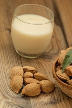 Almond milk with almonds on a wooden table and focus with shallow depth of field 