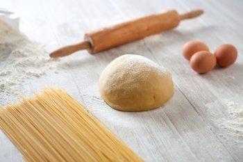 Kitchen table with flour and dough spaghetti