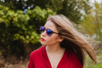 Pretty blonde girl with red clothes in the park