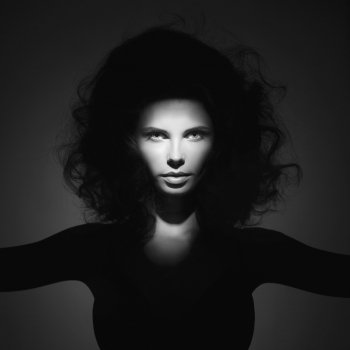 Black and white studio fashion portrait of beautiful woman with volume wavy hair. Big hair