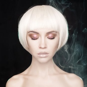 Art fashion studio portrait of beautiful blonde with short haircut. Glamour photo with smoke on background