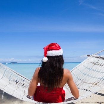 Woman in hammock celebrating Christmas. Woman in hammock on tropical beach celebrating Christmas