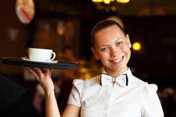 Portrait of young waitress in white blouse holding a tray