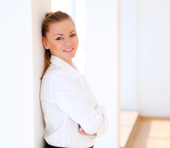 portrait of a young pretty woman standing inside office building