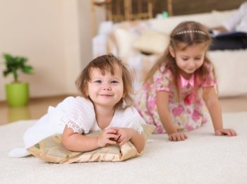 an older sister playing with a toddler sister at home